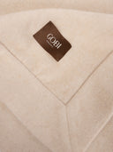 Close-up of a beige fabric with a brown label featuring the brand 'Gobi'. #color_beige