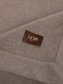 Close-up of a brown 'Gobi Organic' label on gray fabric.