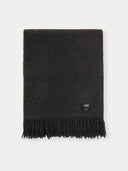 a dark fringed blanket with a small label "GOBI"on a light gray background #color_charcoal