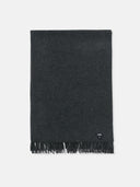 A dark colored cashmere blanket with fringe, displayed neatly folded and hanging. #color_charcoal