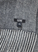 close up of a gray blanket with a small label "GOBI" #color_charcoal