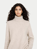 Woman wearing a beige turtleneck sweater on a white background #color_dawn-blue