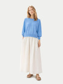front view of a woman wearing a blue dolman sleeve sweater and white skirt on a white background #color_azure-blue