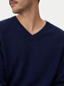 close up of a Navy blue v-neck sweater worn by a person on a light gray background #color_navy