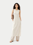 Woman wearing a white sleeveless dress with a brown bag on a white background #color_marshmallow