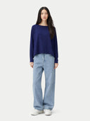 Woman wearing a navy blue sweater and light blue jeans on a white background #color_navy