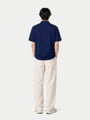 back view of a navy blue polo shirt and light-colored pants on a white background