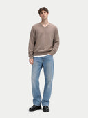 Man wearing a brown sweater and blue jeans on a white background #color_taupe