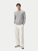 front view of a man wearing a gray turtleneck sweater and white pants on a white background #color_high-rise