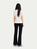 back view of a person wearing a white top and black pants on a white background #color_whisper-white