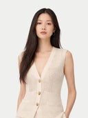 Woman wearing a beige knitted vest on a white background #color_off-white