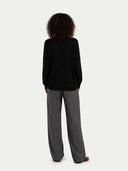 Back view of a person wearing a black sweater and gray pants on a white background #color_blue-graphite