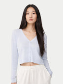 Woman wearing a light blue cardigan over a white top on a white background #color_ice-flow