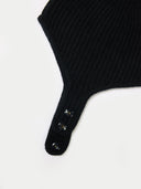 close up of a black cashmere knitted aviator cap with buttons on a light gray background #color_black