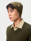 Model wearing the Unisex Seamless Cashmere Logo-Patch Beanie in Muted Green, close front view