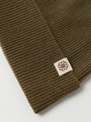 The Unisex Seamless Cashmere Logo-Patch Beanie in Muted Green, close-up of the cashmere knit