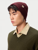 Model wearing the Unisex Seamless Cashmere Logo-Patch Beanie in Wine Red, close front view
