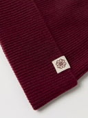 The Unisex Seamless Cashmere Logo-Patch Beanie in Wine Red, close-up of the cashmere knit
