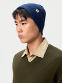 Model wearing the Unisex Seamless Cashmere Logo-Patch Beanie in Deep Blue, close front view