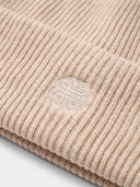 Close-up of the Unisex Seamless Cashmere Ribbed Beanie in Beige, showing the rib knit and the embroidered monogram on the turn-up cuff