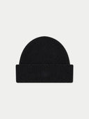 A black ribbed knit beanie hat with a folded cuff, featuring a subtle tonal embroidered logo on the front, set against a light gray background.