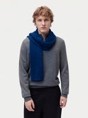 Model wearing the Cashmere Classic Knitted Scarf in Deep Blue, worn around the neck