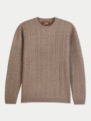 A taupe cable-knit crewneck sweater with a brown leather brand label reading 'COBI' on the inner collar, displayed flat against a light gray background.