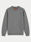 A gray cable-knit crewneck sweater with a brown brand label on the inner collar, displayed flat against a light gray background.
