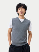 Person wearing a gray vest over a white shirt on a plain background #color_dim-gray