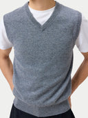 close up front view of a gray v-neck sweater vest over a white shirt on a plain background #color_dim-gray