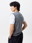 back view of a person wearing a gray vest over a white shirt on a plain background #color_dim-gray