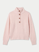 A light pink ribbed knit mock-neck sweater with a short button placket and four brown buttons, displayed on a clean off-white background.