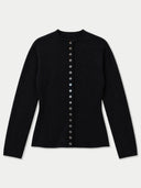 A black long-sleeve knit top with a round neckline and a vertical row of decorative buttons down the front, displayed on a light gray background.