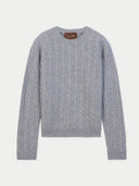 A light gray cable-knit crewneck sweater with ribbed cuffs and hem, featuring a brown Gori brand label at the collar, displayed on a clean off-white background.