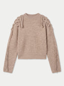 A ribbed knit long-sleeve sweater in a dusty rose-beige color, featuring decorative knotted bow details on the shoulders and matching ribbed detailing down the sleeves, shown against a light gray background.