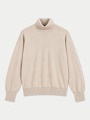 A light beige knit turtleneck sweater with long sleeves and ribbed cuffs and hem, displayed flat against a light gray background.