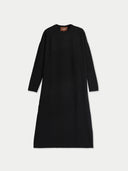 A black long-sleeve knit dress with a crew neck, shown flat against a light gray background. A small brown brand label is visible inside the neckline.