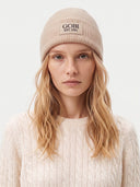Model wearing the Seamless Cashmere Rib-Knit Beanie in Beige, front view