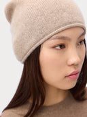 Model wearing the Women's Lightweight Seamless Cashmere Beanie in Natural Beige, close front view