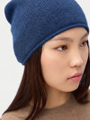 Model wearing the Women's Lightweight Seamless Cashmere Beanie in Deep Blue, close front view