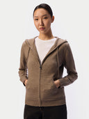 Model wearing the taupe cashmere zip hoodie open over a white tee, hands in the smiley pockets, front view