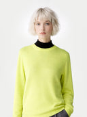 Person wearing a bright yellow sweater over a black turtleneck on a white background #color_sunny-lime