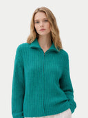 Woman wearing a teal knitted cardigan on a light gray background #color_dynasty-green
