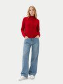 front view of a woman wearing a red sweater and blue jeans on a white background #color_chili-pepper