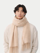 Man wearing a beige scarf against a white background.