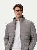 Man wearing a gray puffer jacket over a white shirt on a light gray background #color_dim-gray