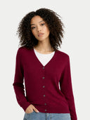 Woman wearing a burgundy cardigan over a white shirt on a plain background #color_bordeaux
