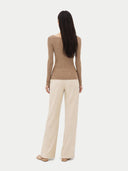 back view of a woman wearing a brown long-sleeve top and beige pants on a white background #color_timber-wolf