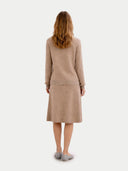 back view of woman wearing a beige dress with a plain white background #color_warm-grey