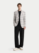 Man wearing a checkered blazer over a black shirt with black pants on a white background #color_off-white